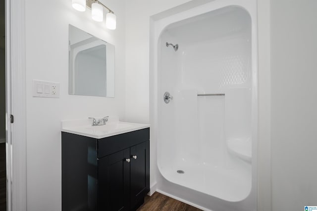 bathroom featuring vanity, a shower, and wood-type flooring