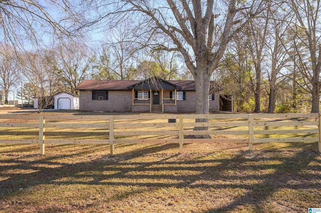 single story home with a garage, an outbuilding, and a front yard