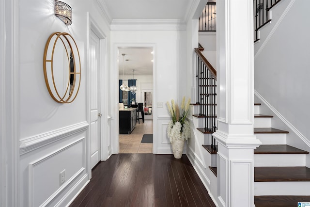 entryway featuring a notable chandelier, hardwood / wood-style flooring, and ornamental molding