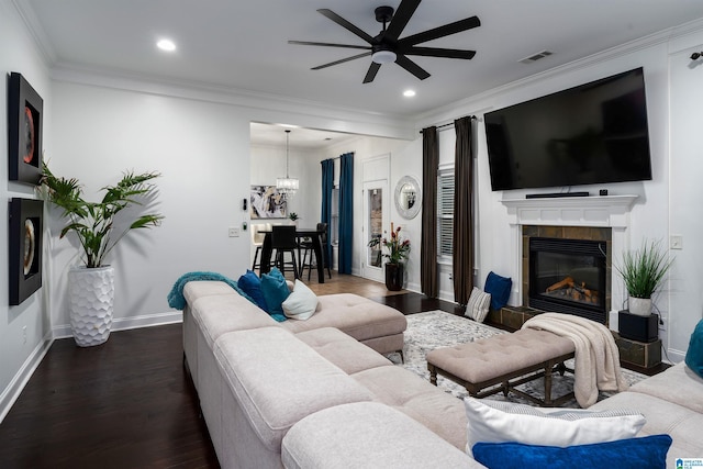 living room featuring a tile fireplace, hardwood / wood-style flooring, ceiling fan, and ornamental molding