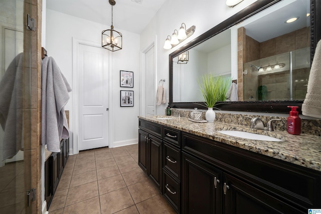 bathroom with a shower with door, a chandelier, tile patterned floors, and vanity