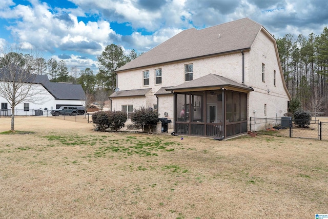 rear view of house with a sunroom and a yard