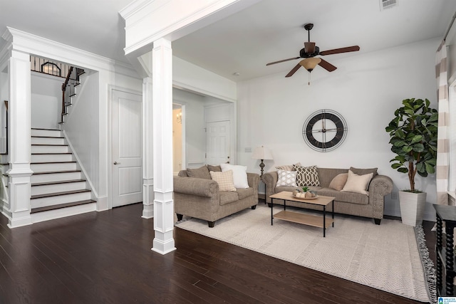 living room with dark hardwood / wood-style flooring, ceiling fan, and ornate columns