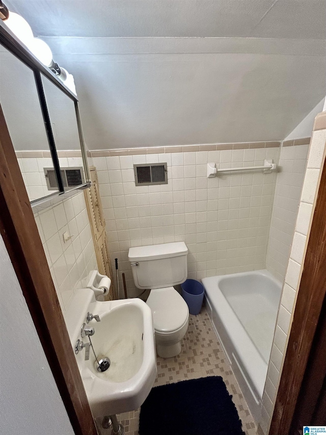 bathroom with toilet, tile walls, sink, and a bathing tub