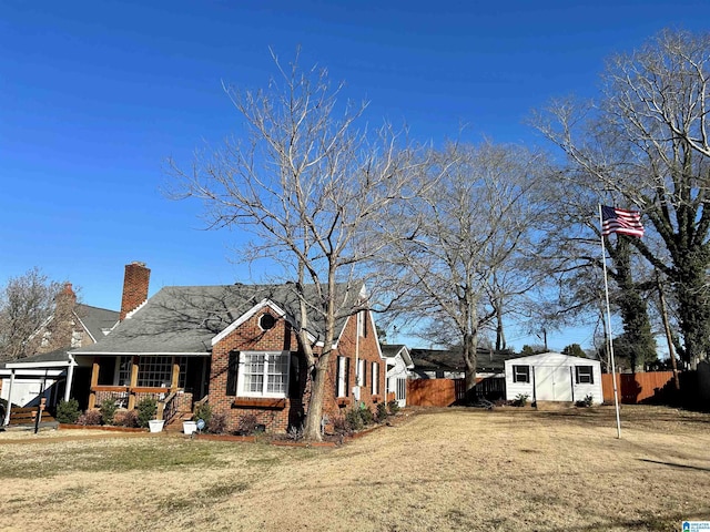 view of side of home featuring a lawn, a storage unit, and covered porch