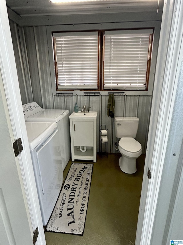 bathroom featuring sink, toilet, and independent washer and dryer