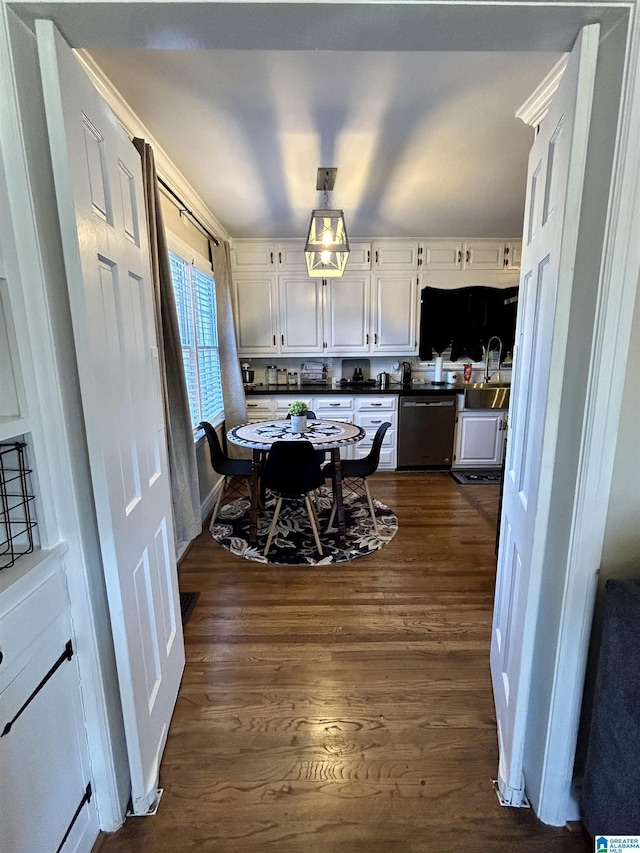 kitchen featuring dark wood-type flooring, white cabinets, and stainless steel dishwasher