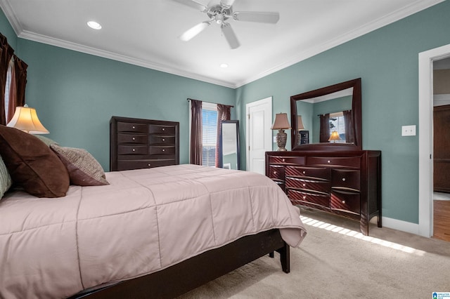 carpeted bedroom with ceiling fan, ornamental molding, and a closet