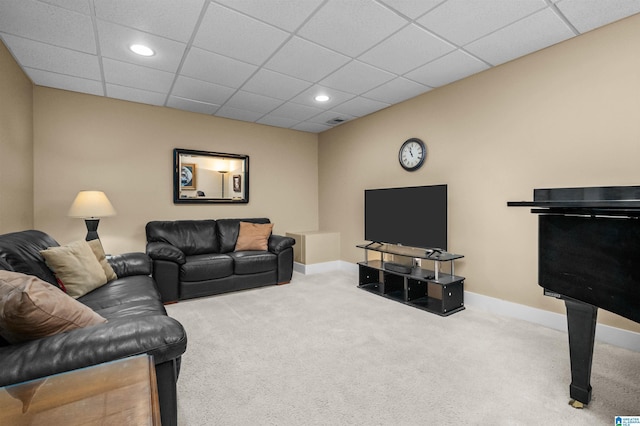 carpeted living room featuring a drop ceiling