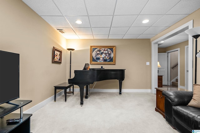 miscellaneous room with a paneled ceiling and light colored carpet