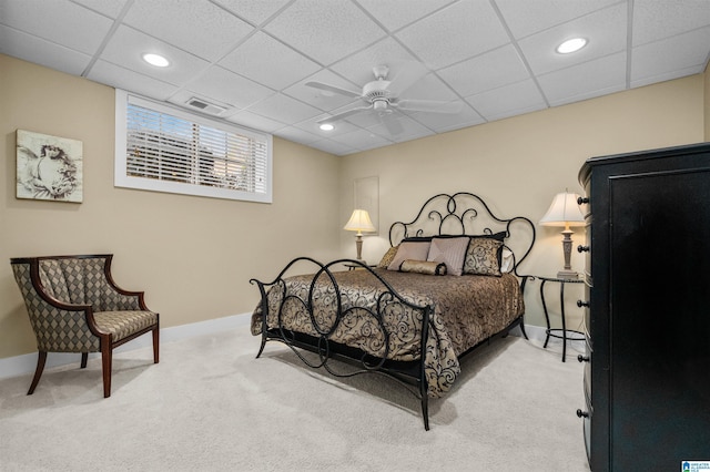 bedroom featuring ceiling fan, light colored carpet, and a drop ceiling