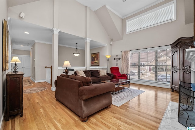 living room featuring crown molding, high vaulted ceiling, and ornate columns