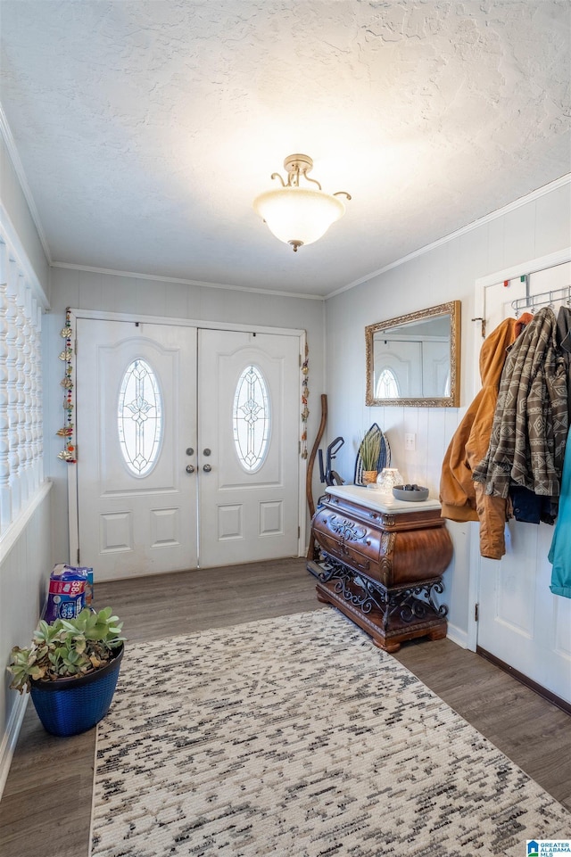 foyer featuring a textured ceiling, dark wood-type flooring, and ornamental molding