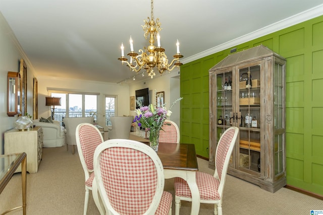 carpeted dining area featuring crown molding and a chandelier