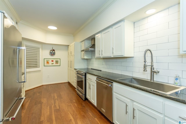 kitchen with sink, wall chimney exhaust hood, white cabinetry, ornamental molding, and stainless steel appliances