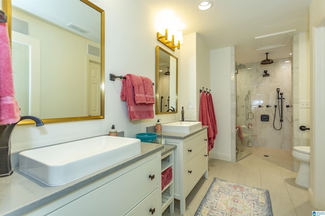 bathroom featuring a shower with door, tile patterned floors, vanity, and toilet