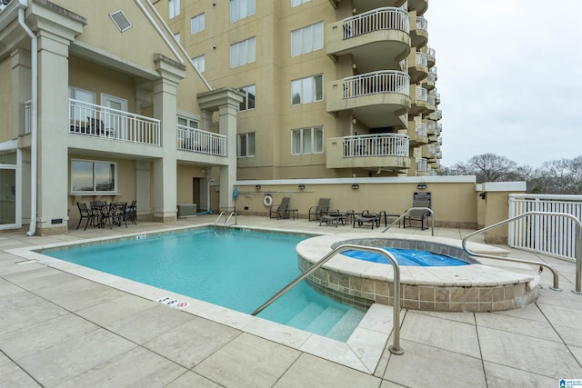 view of pool with a hot tub