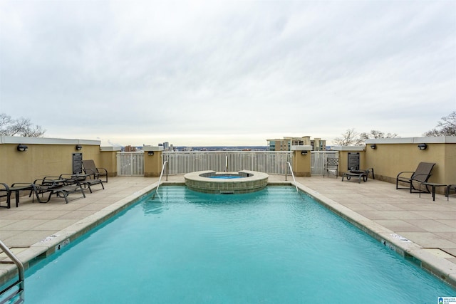 view of swimming pool featuring a patio and a hot tub