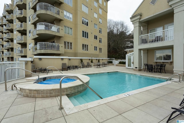 view of swimming pool with a hot tub