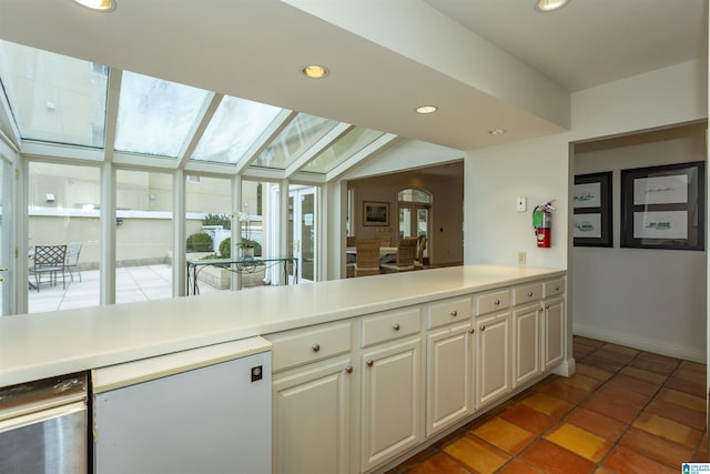 kitchen featuring dark tile patterned flooring, white cabinets, refrigerator, and lofted ceiling