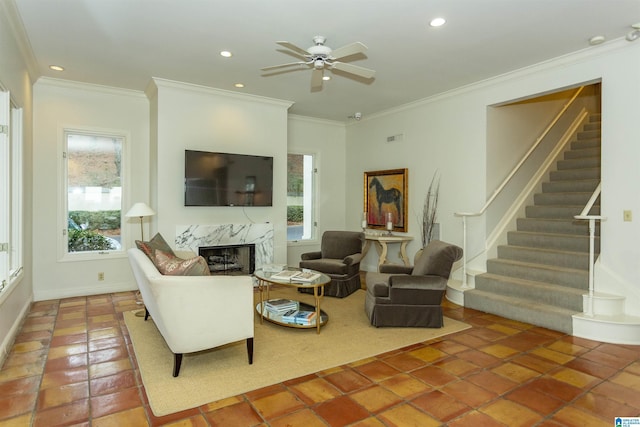 tiled living room featuring a healthy amount of sunlight, a high end fireplace, and ornamental molding