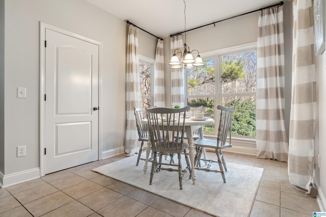 tiled dining room with an inviting chandelier