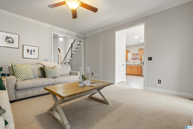 living room with ceiling fan, crown molding, light colored carpet, and sink