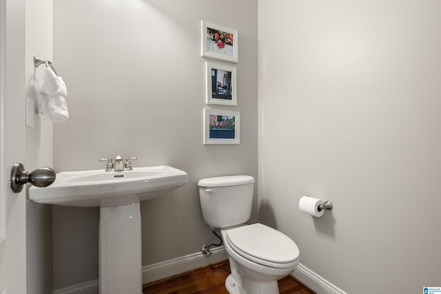 bathroom featuring sink, hardwood / wood-style floors, and toilet