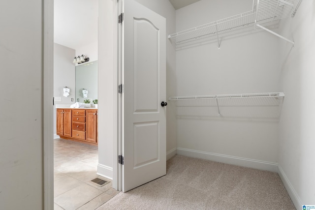 spacious closet featuring light carpet