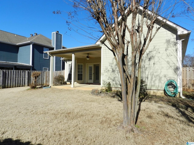 rear view of house featuring ceiling fan, a yard, and a patio