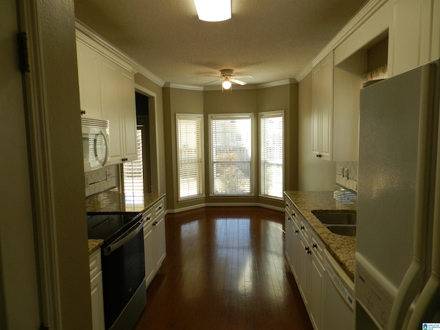 kitchen with white appliances, dark hardwood / wood-style flooring, light stone countertops, white cabinets, and sink