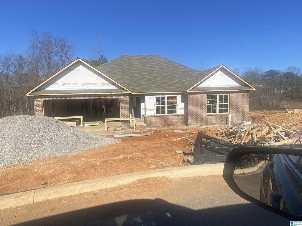 view of front of house with a garage, brick siding, and a shingled roof