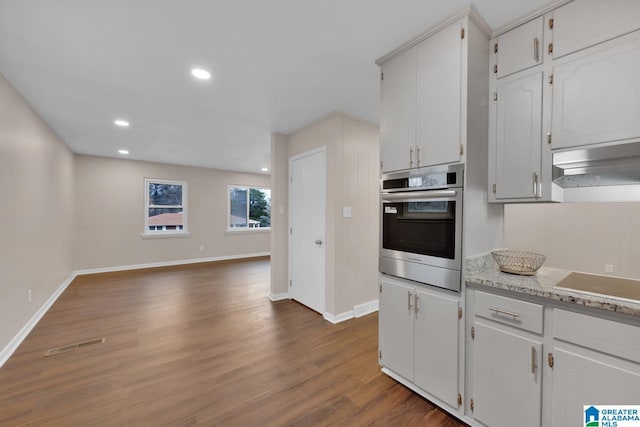 kitchen featuring dark wood-type flooring, white cabinetry, oven, light stone counters, and black electric cooktop