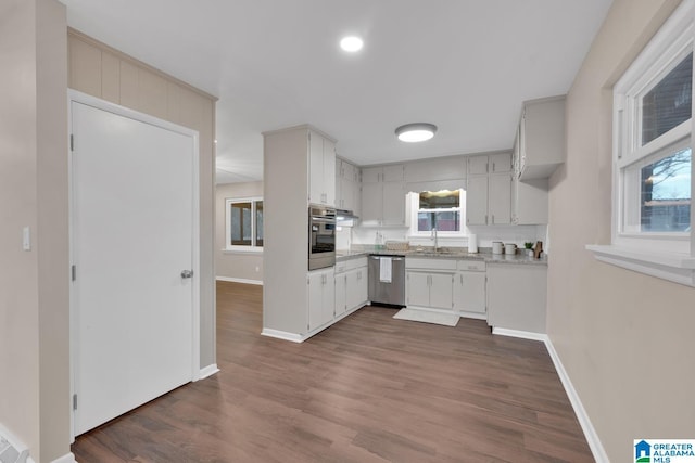 kitchen with sink, stainless steel appliances, dark wood-type flooring, and decorative backsplash