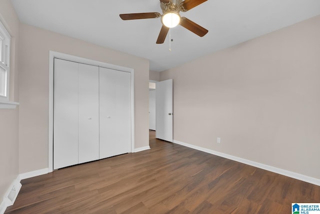 unfurnished bedroom featuring a closet, dark hardwood / wood-style floors, and ceiling fan