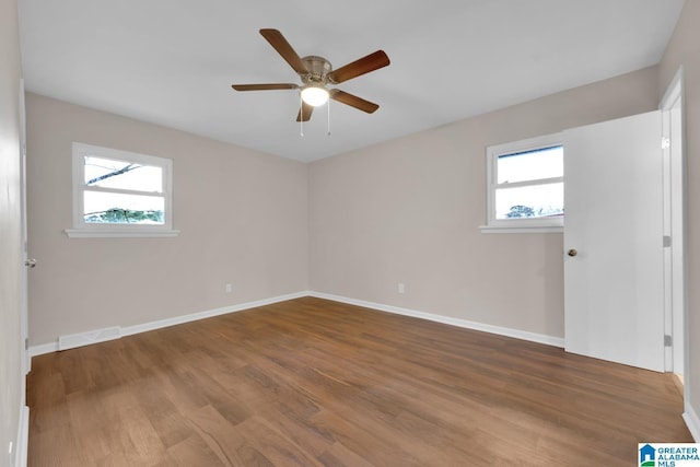 empty room featuring ceiling fan, wood-type flooring, and a healthy amount of sunlight