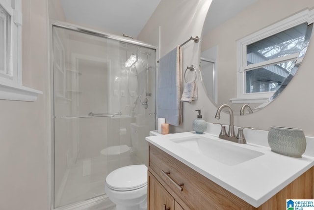 bathroom featuring a shower with door, toilet, and vanity