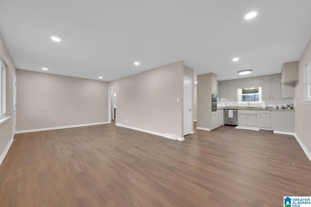 unfurnished living room with dark wood-type flooring and sink