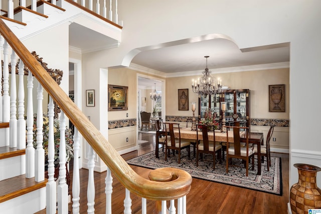 dining space with wood-type flooring, crown molding, and a chandelier