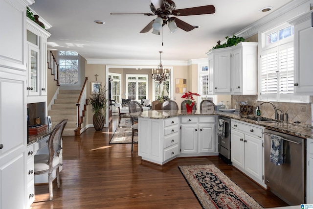 kitchen with white cabinets, decorative light fixtures, kitchen peninsula, and stainless steel dishwasher