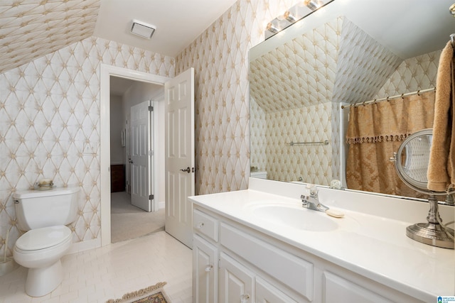 bathroom with toilet, tile patterned flooring, and vanity