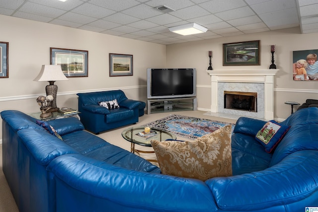 living room with carpet, a high end fireplace, and a paneled ceiling