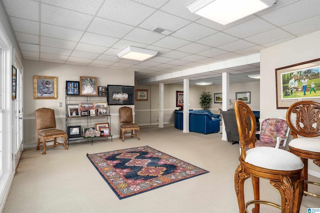 sitting room featuring carpet flooring and a drop ceiling