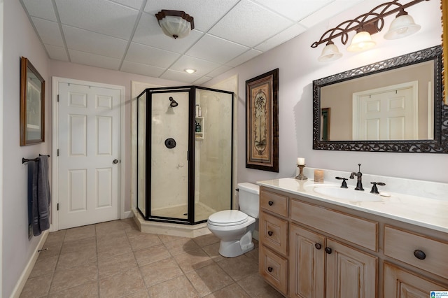 bathroom with a paneled ceiling, toilet, an enclosed shower, and vanity