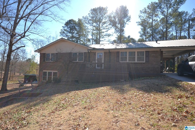 back of house featuring metal roof, a carport, and brick siding