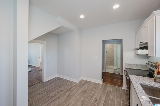 kitchen featuring light stone counters, white cabinetry, and stainless steel electric range