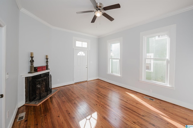 foyer featuring hardwood / wood-style flooring, ceiling fan, crown molding, and plenty of natural light