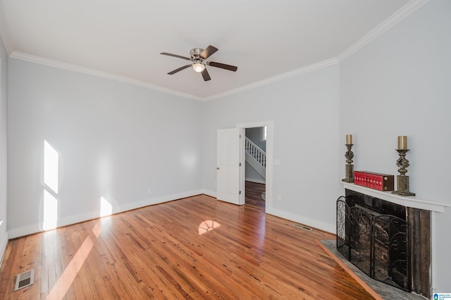 unfurnished living room with hardwood / wood-style flooring, ornamental molding, and ceiling fan