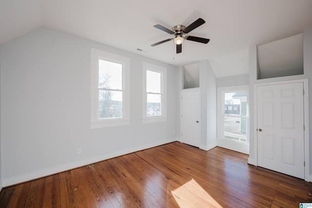 unfurnished bedroom featuring ceiling fan, multiple windows, dark hardwood / wood-style flooring, and lofted ceiling