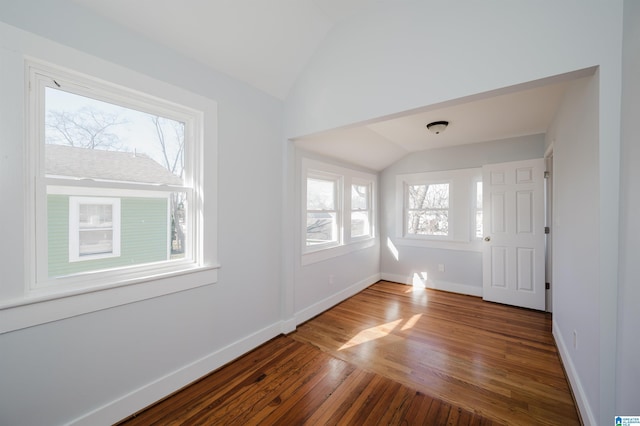 spare room with wood-type flooring and vaulted ceiling